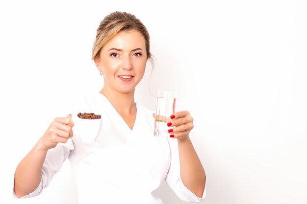 Coffee with water The female nutritionist holds a cup of coffee beans and a glass of water in her hands on white background