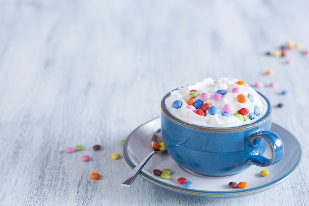 Coffee with whipped cream and colorful chocolate drops