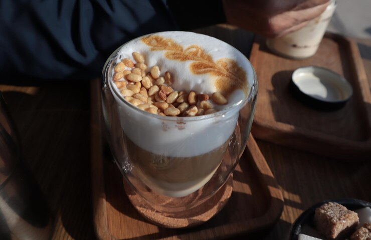 Photo 木製のスタンドの上でクリームと松のナッツでコーヒーを飲む