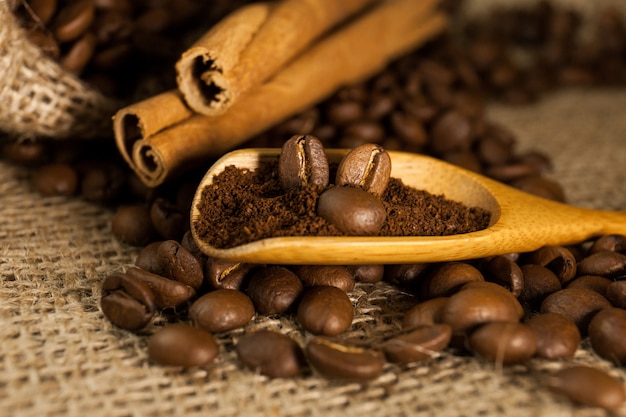 Coffee on wooden spoon on a burlap textured background