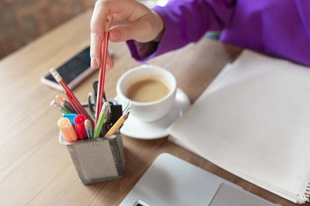 Coffee. Young caucasian business-woman working in office, looks stylish. Paperwork, analyzing, looking for desicion. Concept of finance, business, girl power, inclusion, diversity, feminism Close up