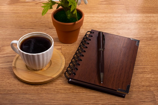 木製の背景のコーヒー計算機とノートブック