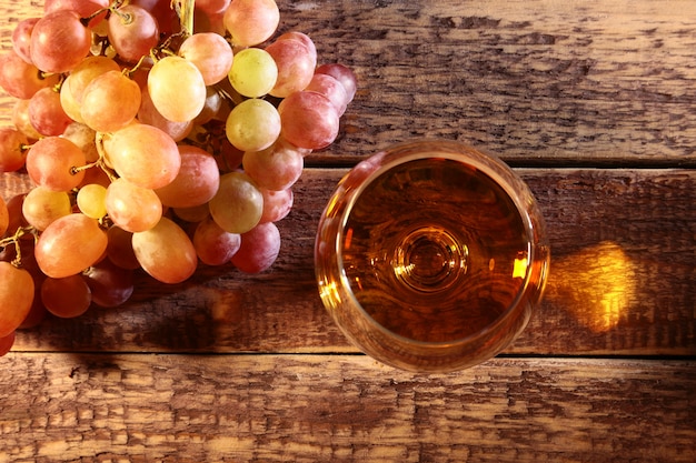 Cognac or Brandy in a glass and fresh grapes, still life in rustic style