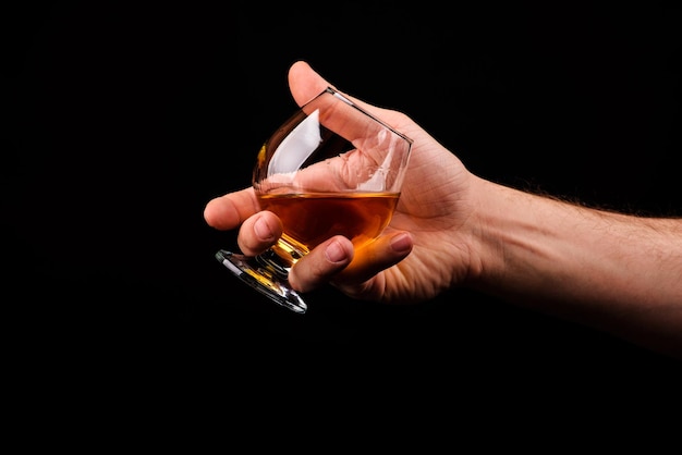 Cognac glass in a hand of a man