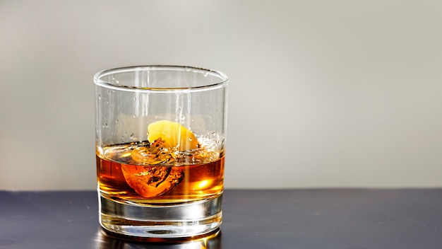 Cognac in een glas met ijs op zwarte tafel