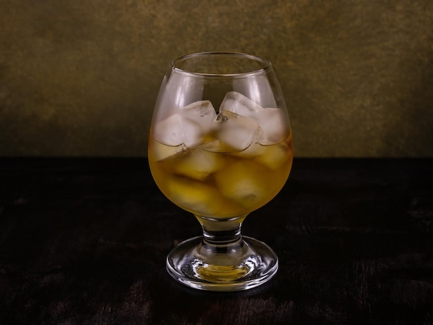 Cognac in a special glass filled with ice cubes close up