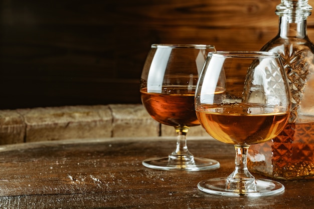 Cognac or whiskey in glasses on rustic table