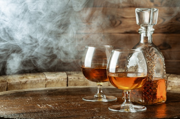 Cognac or whiskey in glasses on rustic 