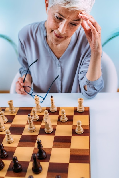 인지 재활 활동 체스를 두는 노인 여성