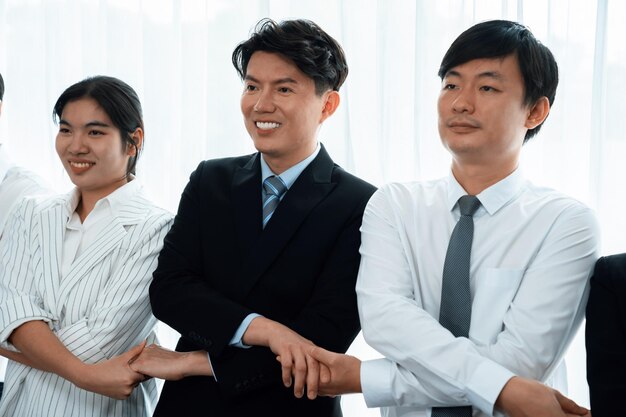 Cohesive office workers holding hand in line to promote harmony in workplace