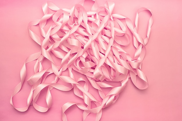 A coil of decorative satin ribbons of pink color.