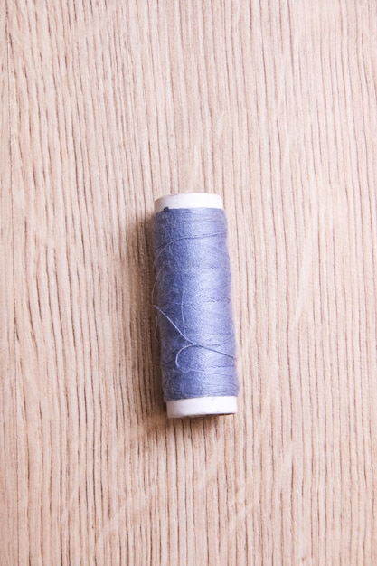 Coil of grey thread on a wooden table