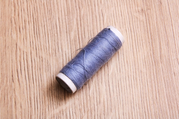Coil of grey thread on a wooden table