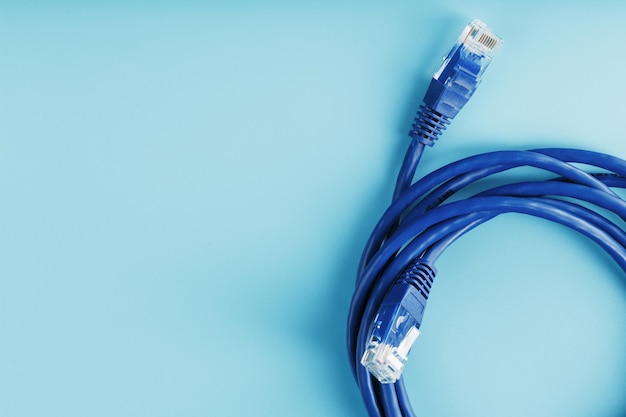 青い背景のデータ伝送用のインターネットネットワークケーブルのコイル