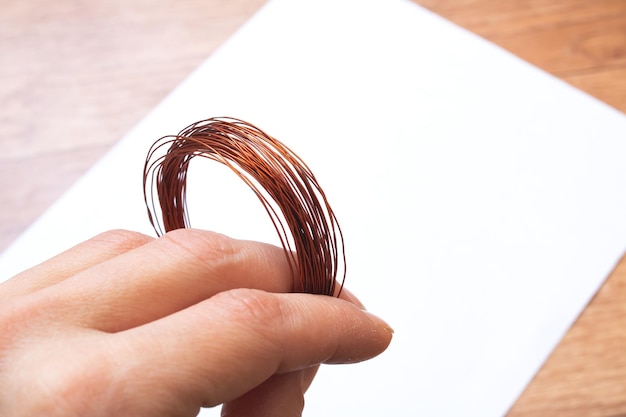 Coil of opper wire in hand closeup