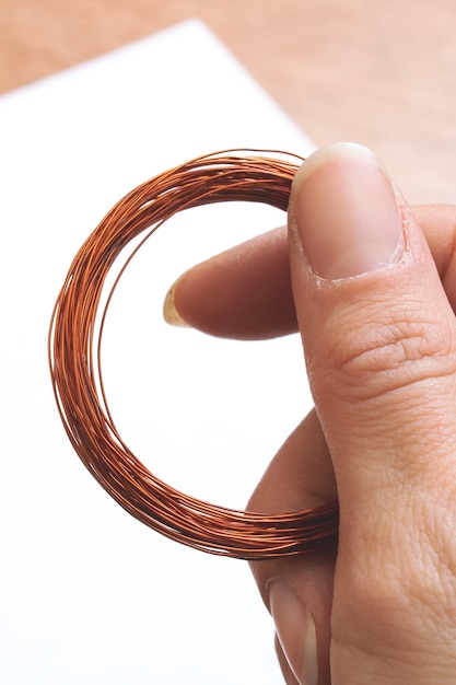 Coil of opper wire in hand closeup