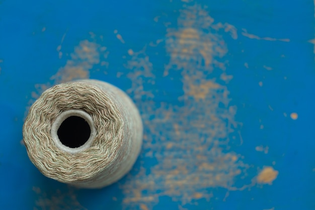 Photo coil with gray threads on a blue wooden surface