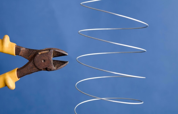 coiled metal wire cutting pliers, blue background