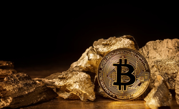 Coin bitcoin next to pieces of gold