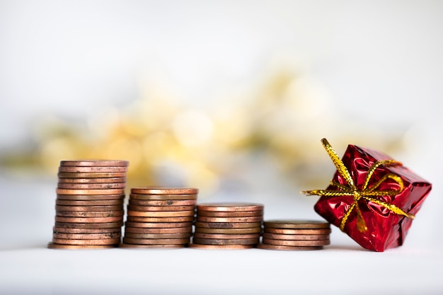 Coin climbing stairs with christmas holiday present sparkling and shiny background financesaving