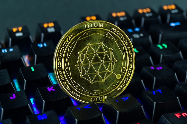 Монета криптовалюты Qtum close-up клавиатуры с цветовой кодировкой
