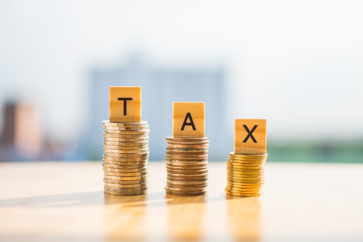 Photo coin of money on wooden table and text tax save with blur background.