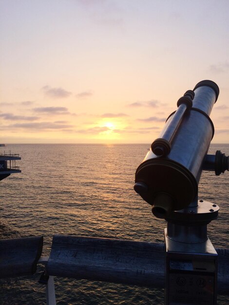 Foto binocoli a monete sul mare contro il cielo durante il tramonto