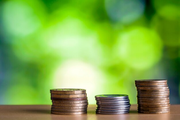 Coin sstacks with green and blue sparkling bokeh background. Financial growth, saving money, business finance wealth and success concept.