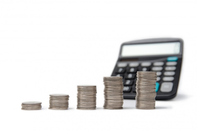 Coin stacks and calculator on white.