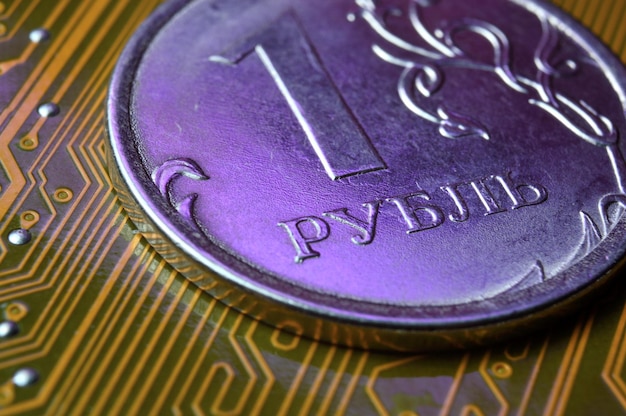額面1ルーブルのコインはマイクロサーキットのクローズアップにありますコインの碑文の翻訳quot1ルーブルquotロシア連邦のデジタル経済の概念