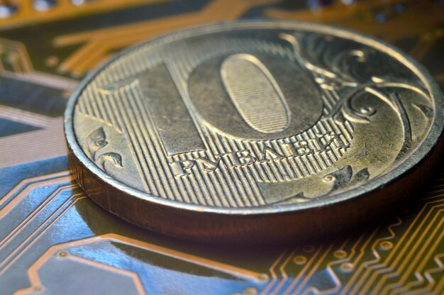 A coin with a face value of 10 rubles lies on a microcircuit closeup Translation of the inscription on the coin quot10 rublesquot The concept of the digital economy in the Russian Federation