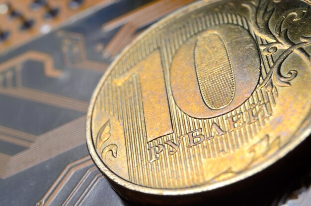 A coin with a face value of 10 rubles lies on a microcircuit closeup Translation of the inscription on the coin quot10 rublesquot The concept of the digital economy in the Russian Federation