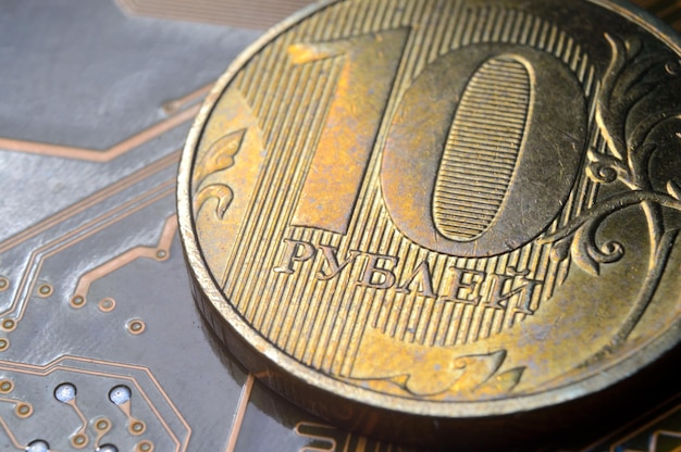 A coin with a face value of 10 rubles lies on a microcircuit closeup Translation of the inscription on the coin quot10 rublesquot The concept of the digital economy in the Russian Federation