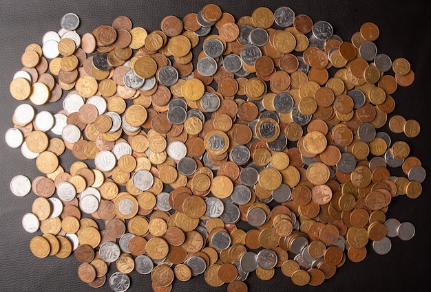 Coins, Brazilian coins of various values ââspread over a black leather surface, top view.