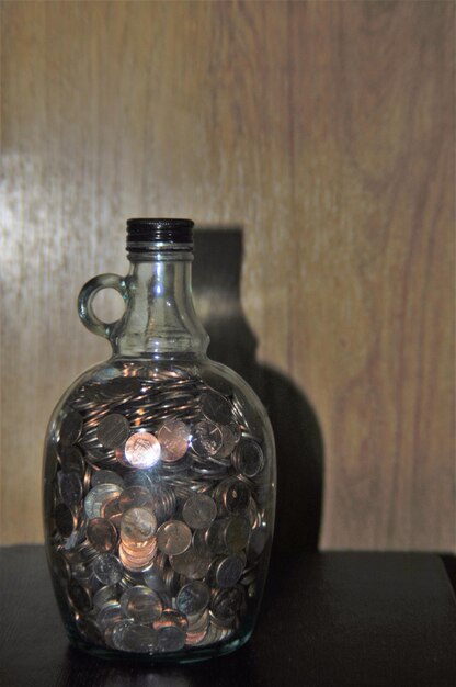 Photo coins in glass bottle on table