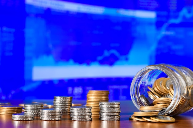 Photo coins in a glass jar on the background of the stock exchange