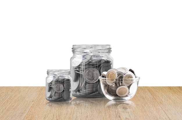 나무 바닥 저축 동전 투자 및 관심 개념에 유리 항아리에 동전 흰색 배경에 고립 된 돼지 저금통에 돈을 성장 돈 개념을 절약