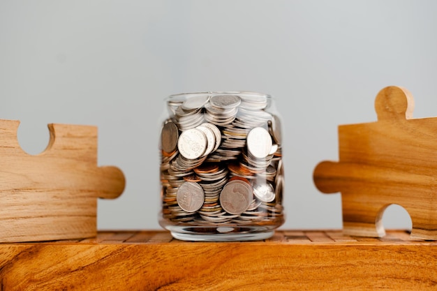 Coins in glass jars and wooden puzzle pieces