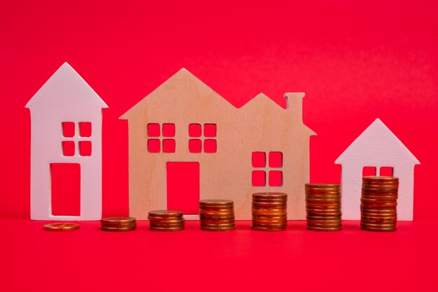 Coins and houses on a red background The concept of the rising price of real estate