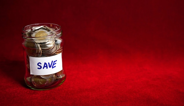 お金を節約する金融の概念のためのガラスの瓶のコイン