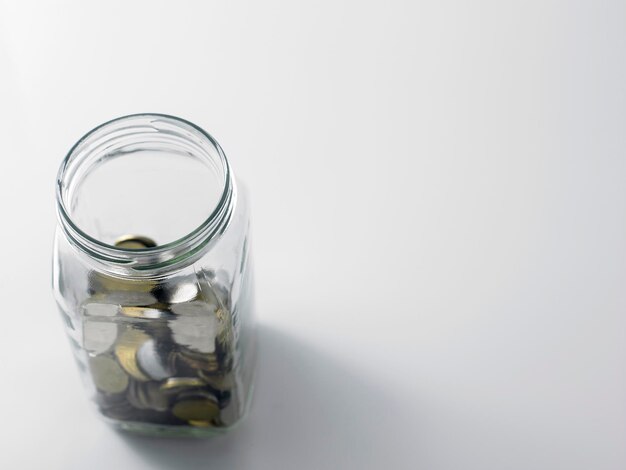 Photo coins in jar over white background