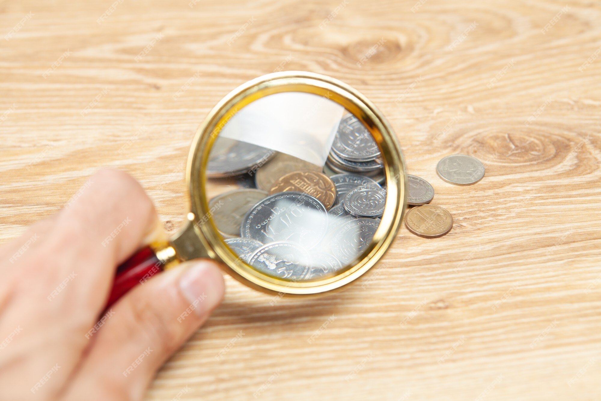 Premium Photo  Magnifying glass looks at the coins on the table