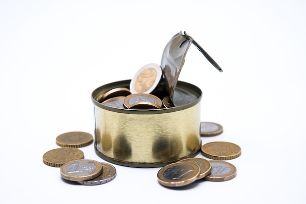 Coins in open tin on white background