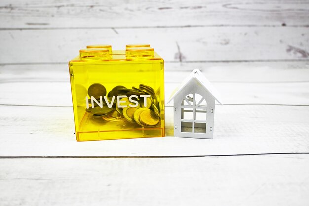 Coins in piggy savings house model account book coins Saving to buy a house or home savings concept Property investment and house mortgage financial concept