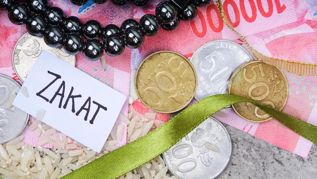 Coins rice grain and rosary Muslim concept for zakat property income and fitrah zakat