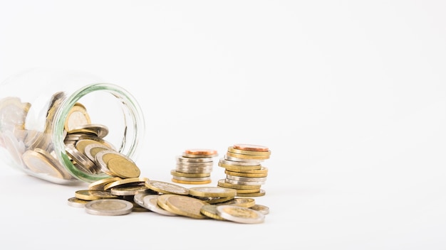 Coins scattered from glass jar