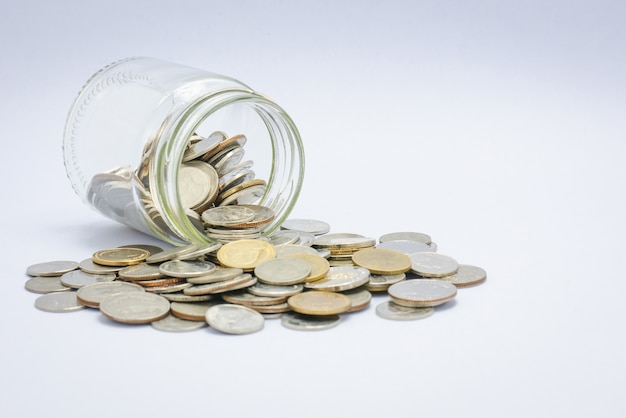 Coins scattered from a glass jar