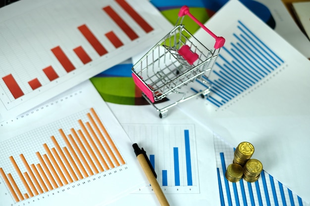 Coins stacks with trolley on financial graph on paper