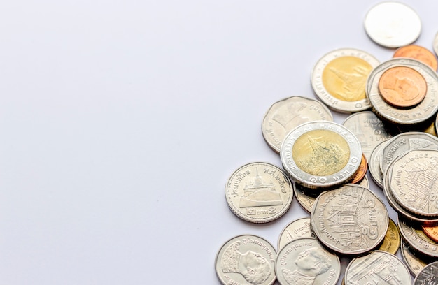 Coins tower (Thai money) on white table with over light and soft-focus in the background