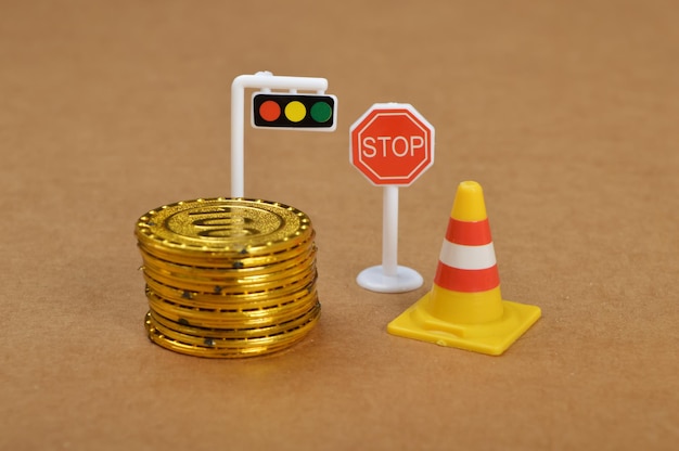 Coins traffic light toy stop sign and plastic cone Violation of traffic rules concept